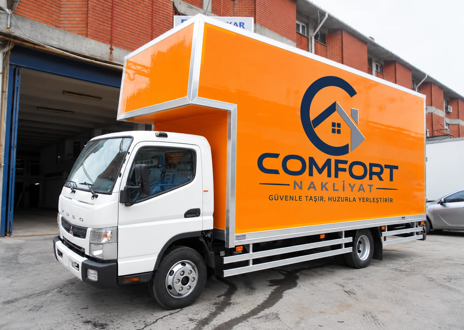 Comfort Nakliyat logolu turuncu kapalı kasa taşıma aracı